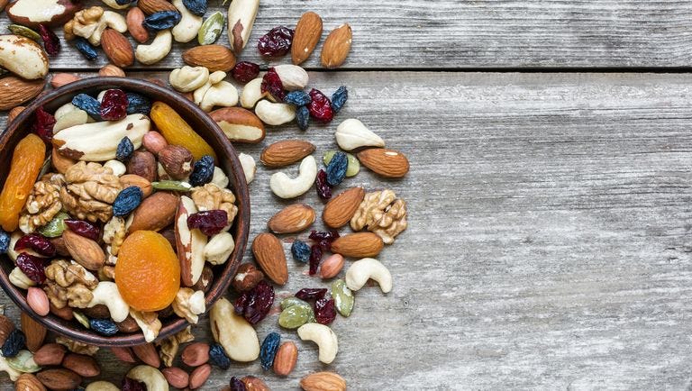 nuts and dried fruits in a bowl over rustic wooden table