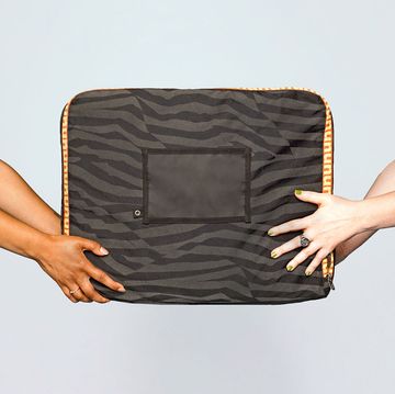 two sets of hands holding a nuuly bag against a light blue background