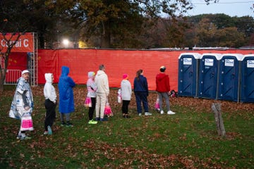 a group of people standing in line for a porta potty