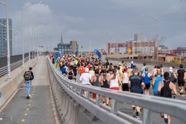 a crowd of runners on a bridge