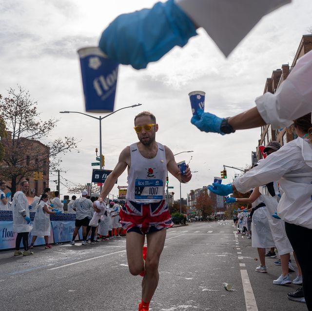a runner grabs a cup of water during the new york city marathon