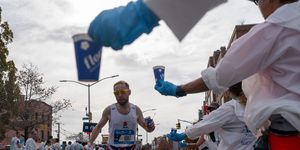 a runner grabs a cup of water during the new york city marathon