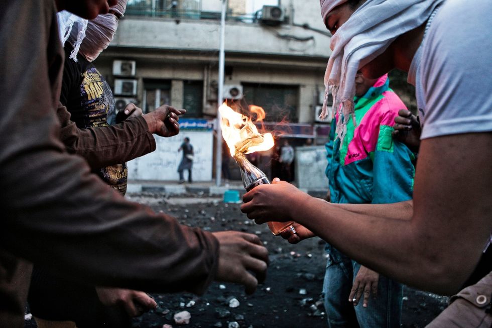 Demonstranten staan in 2012 op het punt om een molotovcocktail naar de politie te gooien tijdens een confrontatie op het Tahrirplein in Cairo