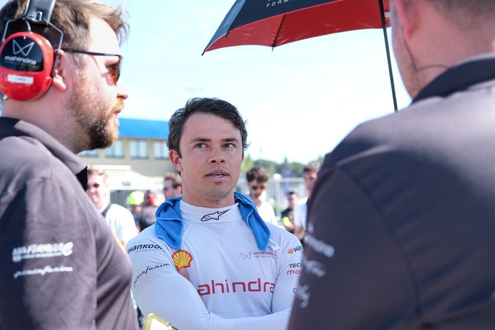 El piloto de Fórmula E, Nyck de Vries, habla con los miembros del equipo en la parrilla antes de una carrera.