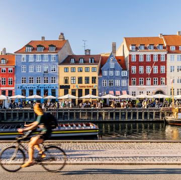 nyhavn harbour with restaurants and crowds of tourists on a sunny summer day, copenhagen, denmark
