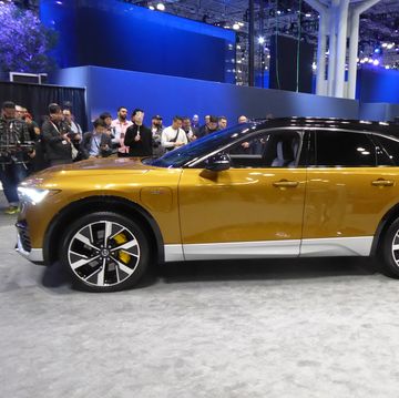 a yellow car parked in a showroom with people standing around 2024 acura zdx type s ev at new york auto show