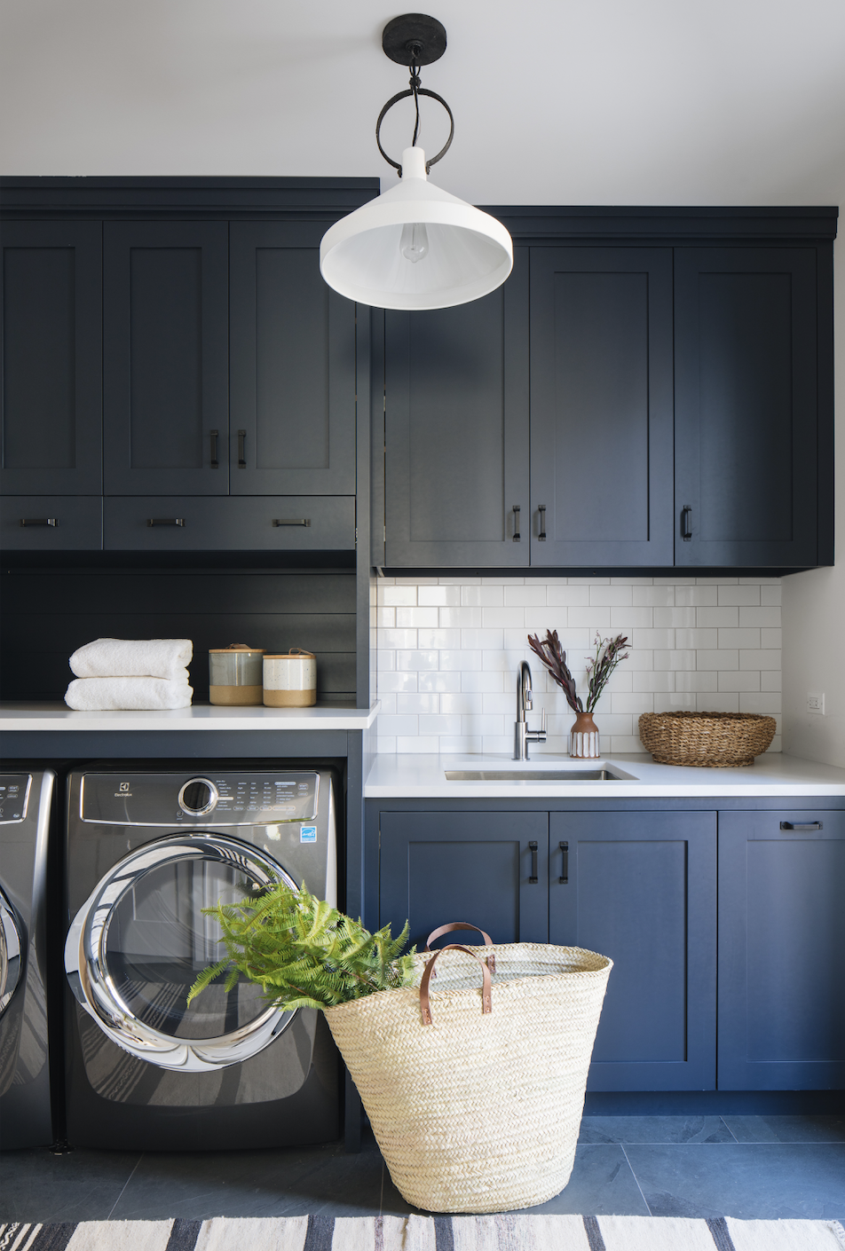 a laundry room with navy cabinets