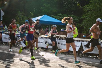 a group of runners grab water during a race