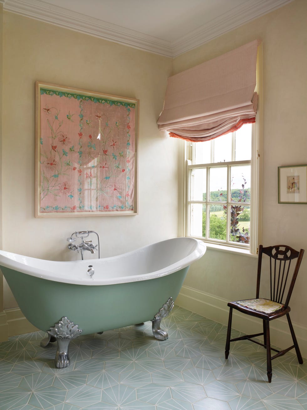 a pale taupe bathroom with freestanding tub and window shade