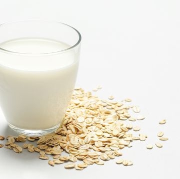 Oat milk and rolled oats. Organic vegan non-dairy plant-based milk in a glass.