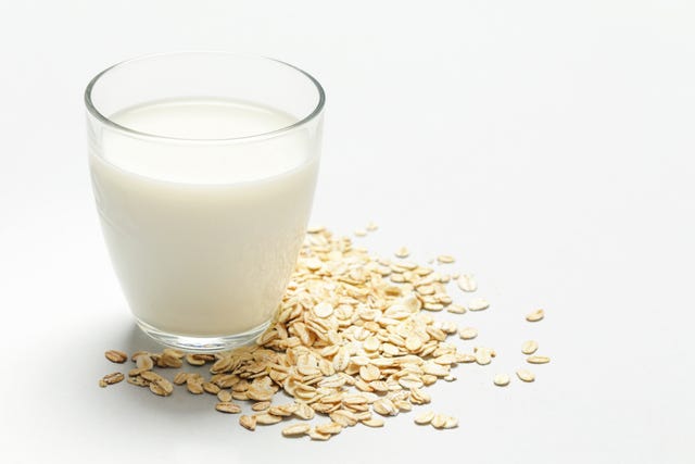 Oat milk and rolled oats. Organic vegan non-dairy plant-based milk in a glass.