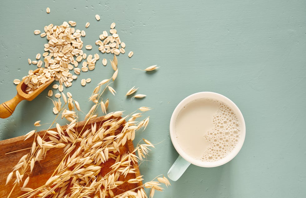 oat milk in a glass and mug on a blue background