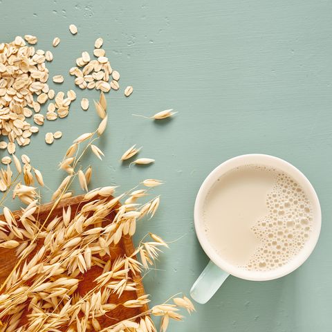 oat milk in a glass and mug on a blue background