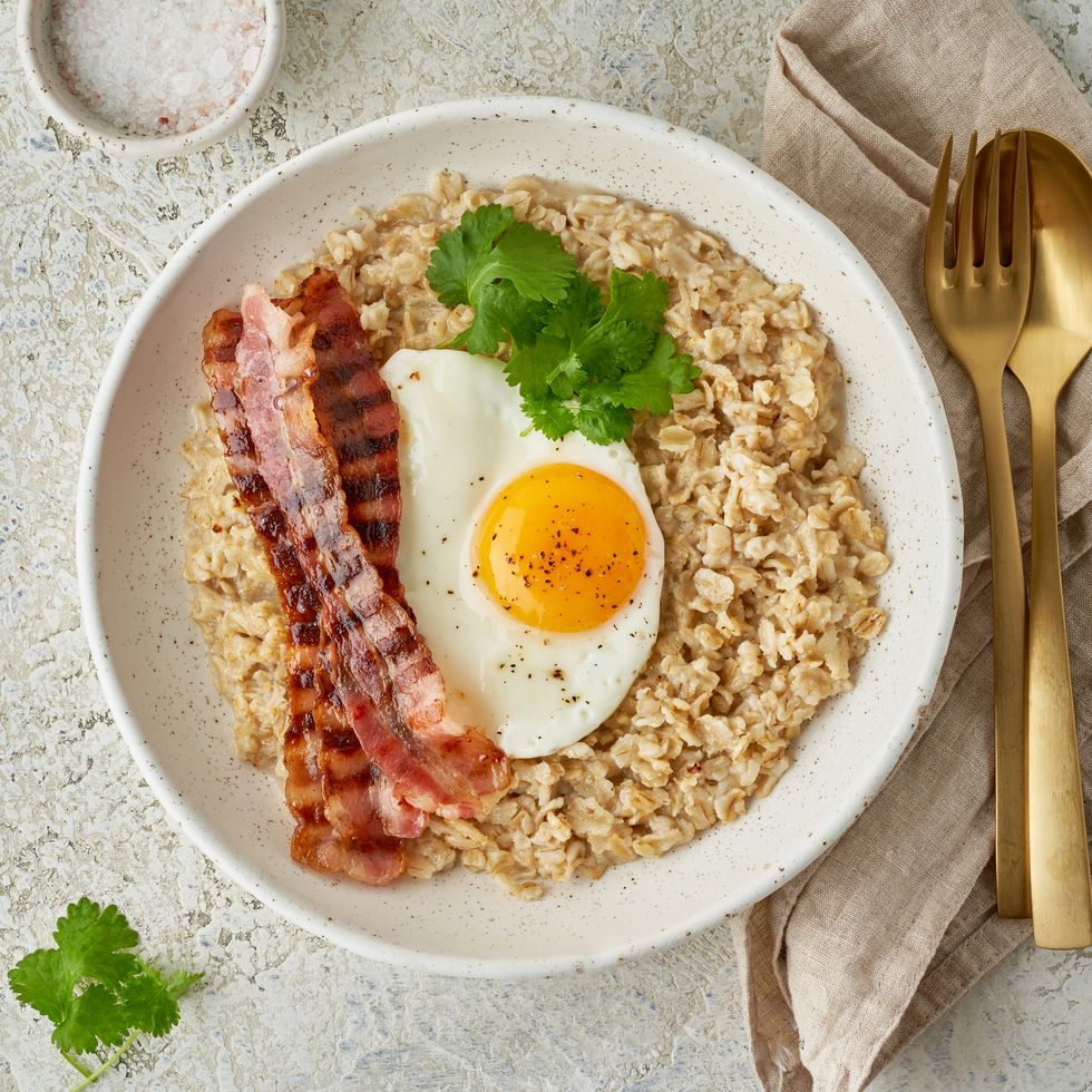 oatmeal, fried egg, fried bacon hearty fat high calorie breakfast, top view