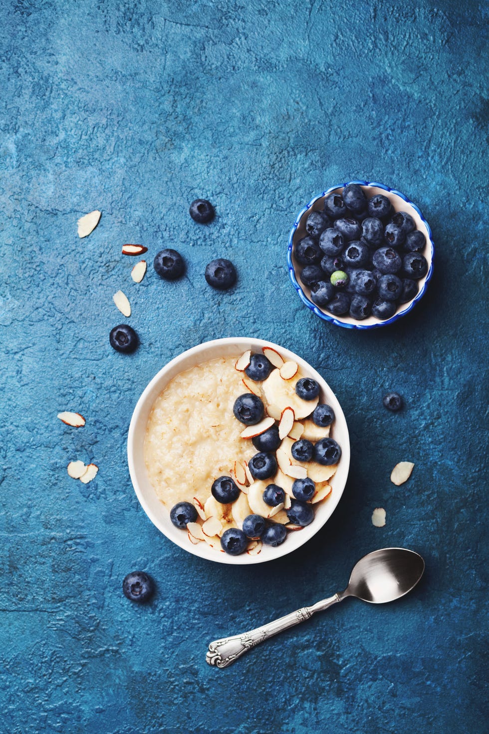oatmeal porridge with banana and blueberry on vintage table top view in flat lay style