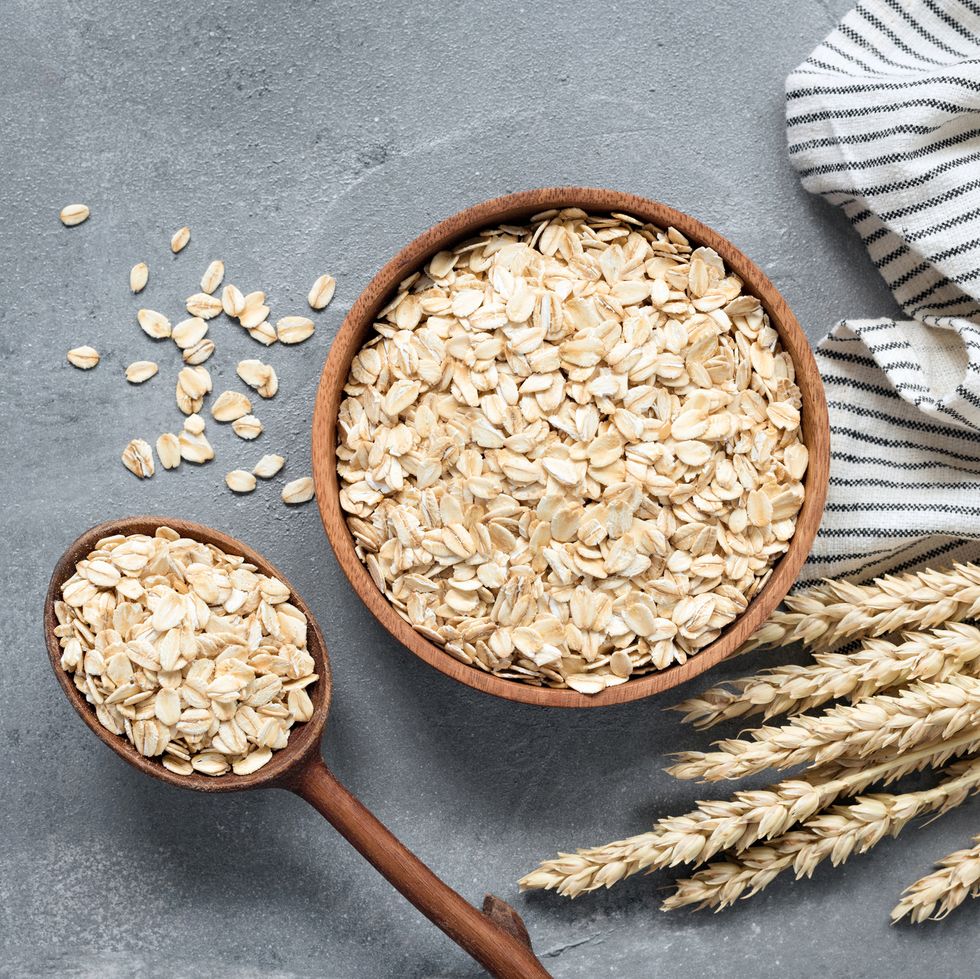 oats, rolled oats or oat flakes in wooden bowl