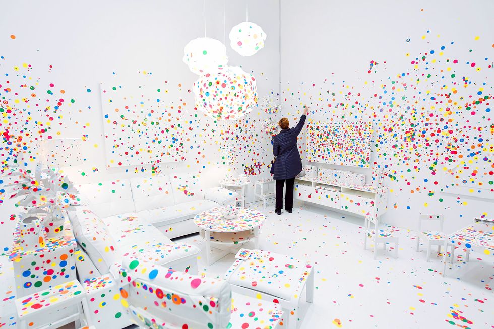 Yayoi Kusamas nieuwste expositie is vernoemd naar haar Infinity Rooms maar de The Obliteration Room De uitwissingskamer is een ander populair kunstwerk van Kusama dat bezoekers uitnodigt tot actieve deelname