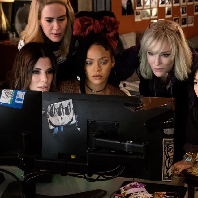 a group of women sitting at a table with a computer
