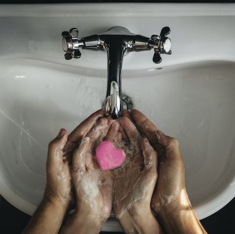 october holidays two sudsy hands holding a heart shaped soap bar over a sink