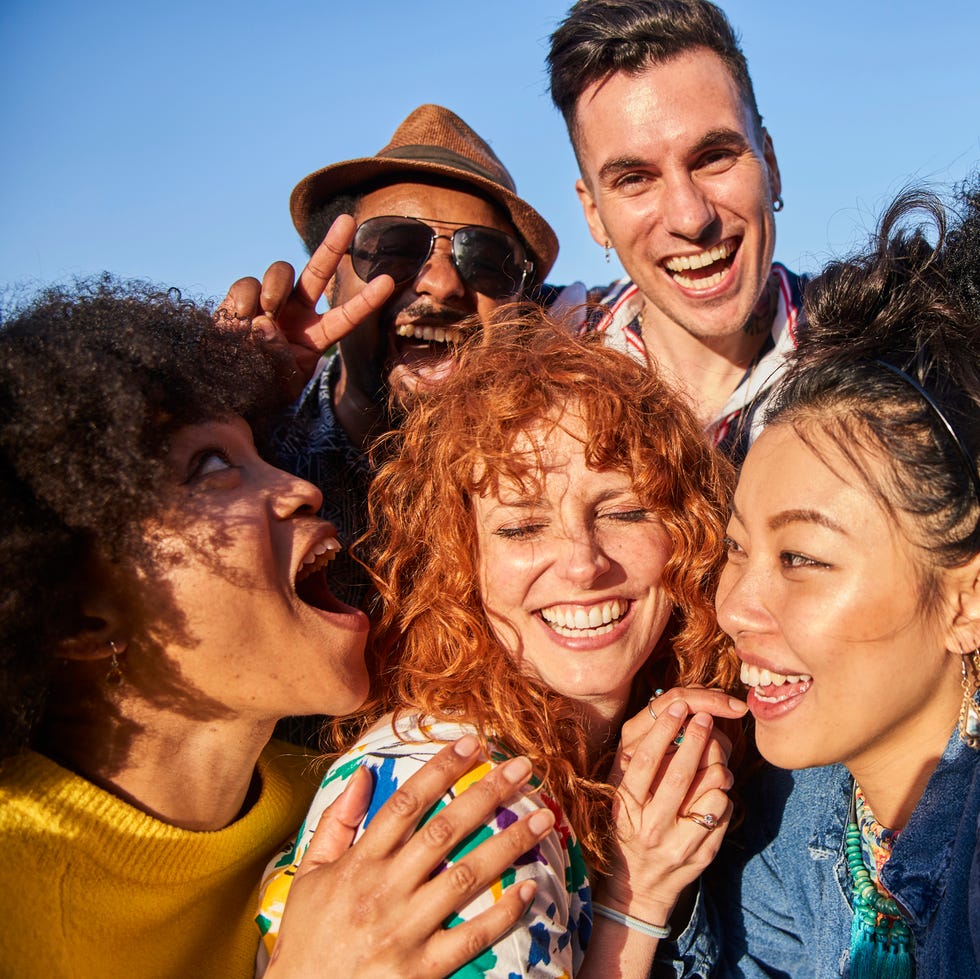 october holidays group of smiling friends taking a selfie together