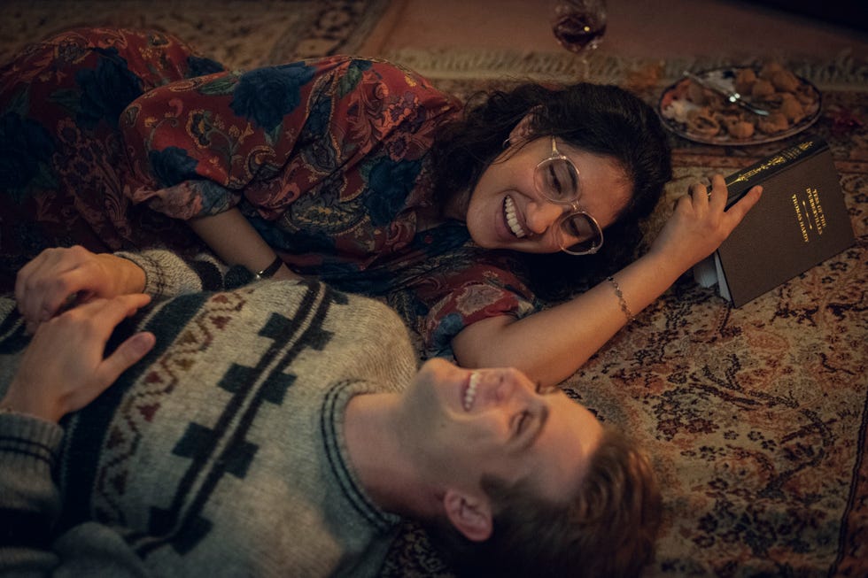 two individuals lying on the floor sharing a moment while holding hands