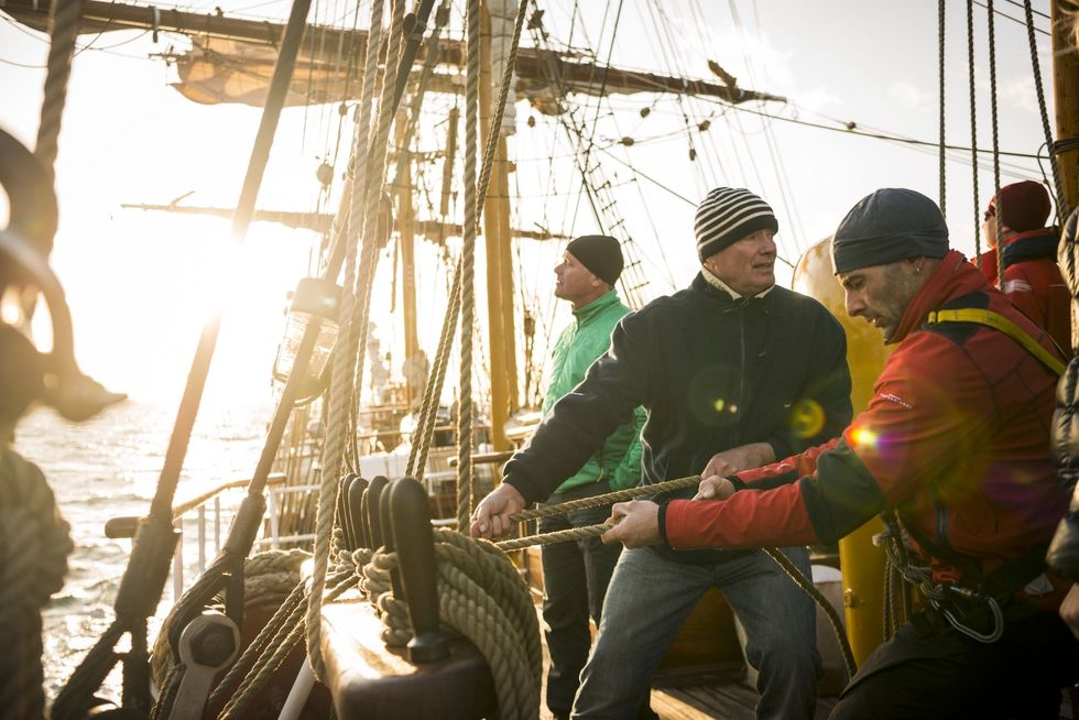 Sail handling is voor iedereen die deelneemt aan de reis Expeditieleider Jordi Plana Morales rechts in beeld doet net zo hard mee