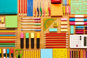 office and school supplies arranged on wooden table knolling