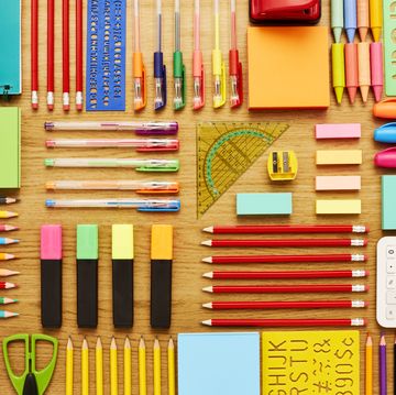 office and school supplies arranged on wooden table knolling