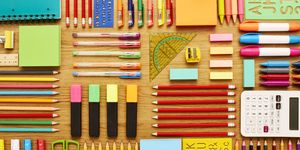 office and school supplies arranged on wooden table knolling