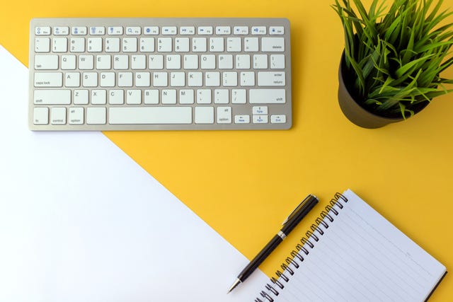 Office Desk With Computer Keyboard and Note Pad