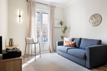 salón con sofá azul y silla metálica negra