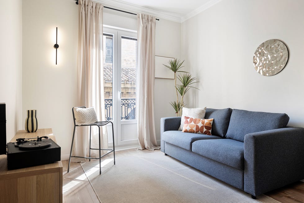 salón con sofá azul y silla metálica negra