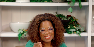 oprah winfrey sititng at a desk with her fingers pointed towards the camera