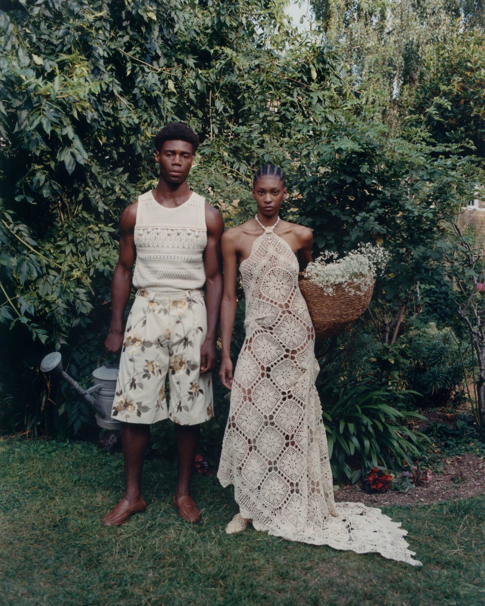 a couple posing in a garden showcasing fashion and floral elements