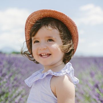 a child smiling in a field of purple flowers