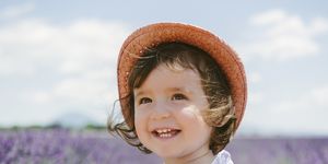 a child smiling in a field of purple flowers