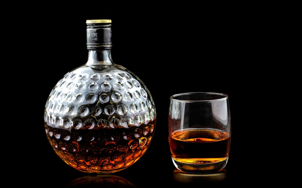 old glass bottle of scotch whiskey on black background