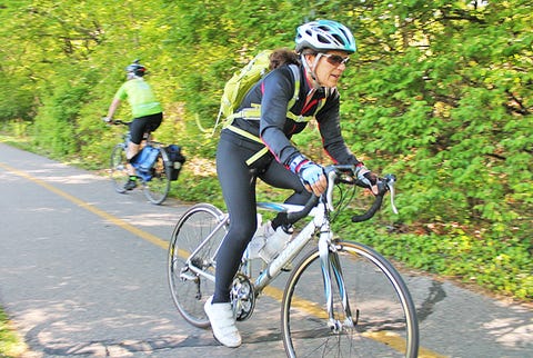 older cyclist riding bike on bike path older cyclist riding bike on bike path
