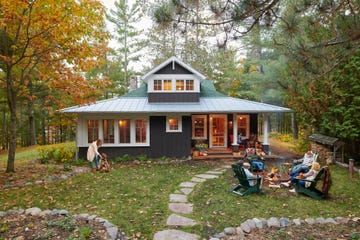 lakeside cabin in cable, wisconsin exterior of green cabin in the fall with campfire and chairs adirondack chairs