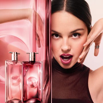 advertising display featuring perfume bottles and a models hand