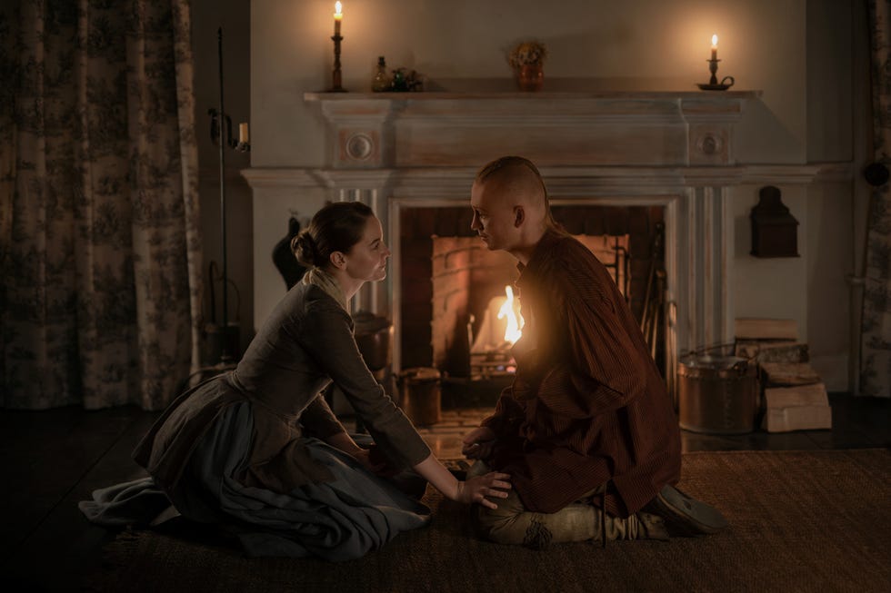 a cozy indoor scene of two individuals engaged in a serious conversation near a fireplace