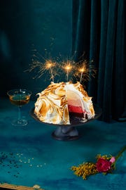 ombré baked alaska cake with ice cream in the center and sparklers on top