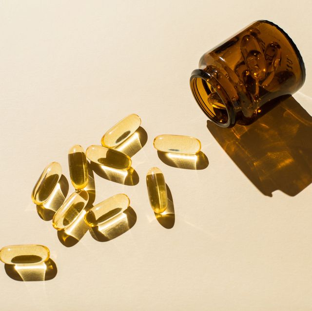 capsules and a glass bottle on a beige background