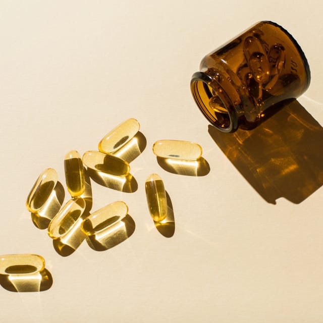 omega 3 fish oil capsules and a glass bottle on a beige background