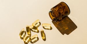 omega 3 fish oil capsules and a glass bottle on a beige background