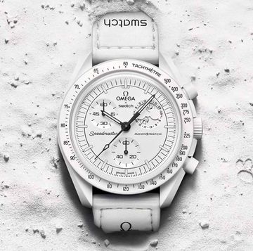 a silver watch on a white surface