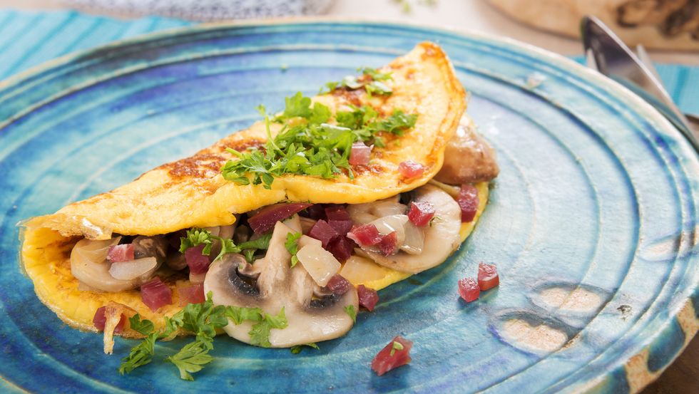 Omelette with champignon, onion and ham on plate