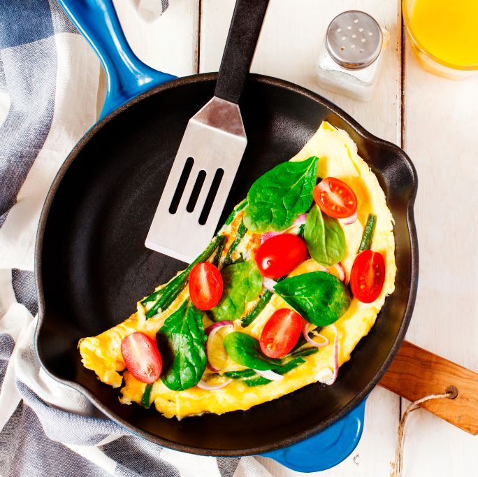 omelette with green bean spinach and tomato in a skillet top view