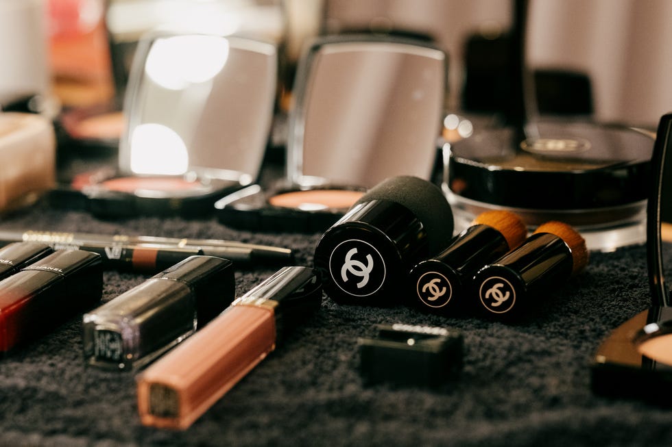 variety of makeup products including lipsticks nail polish and compacts arranged on a surface