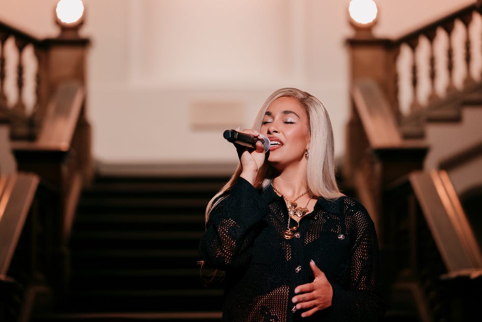 a person singing into a microphone on a staircase